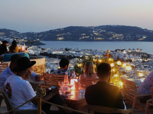 Night-time view of the sea and port in Mykonos from a bar.