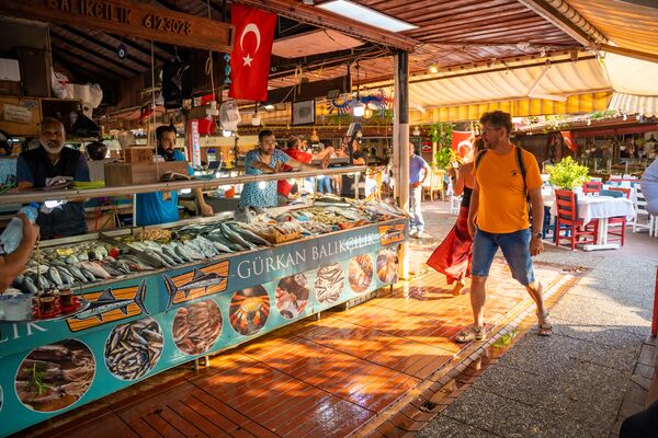 Fethiye, Turkey - June 9, 2023: People visit Fathiye Fish Market of old town with fresh seafood shops and restaurants, Turkey. High quality photo